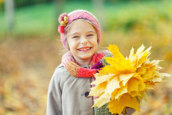 Happy little girl with autumn leaves
